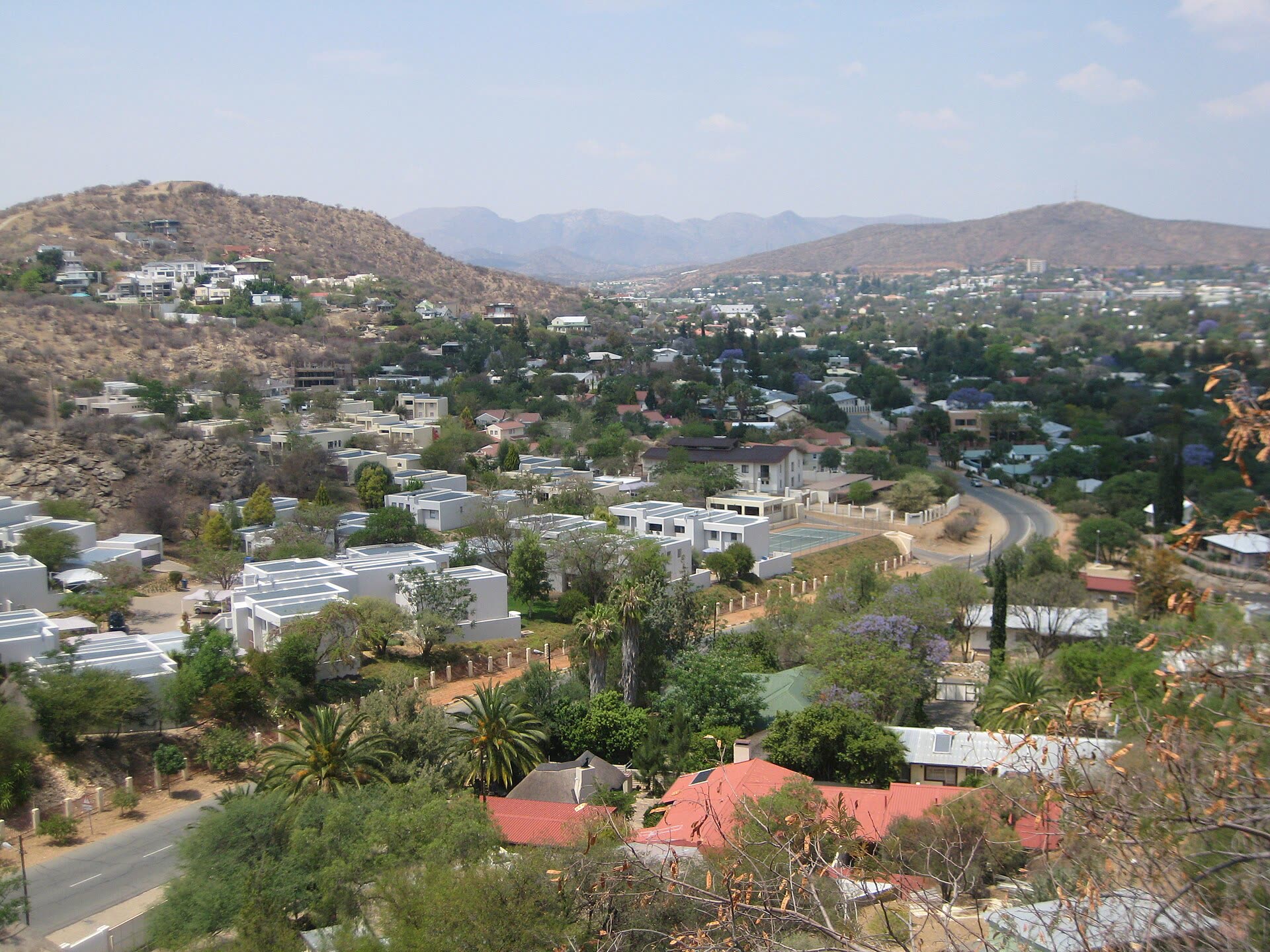 Klein-Windhoek seen from the hills, with houses among trees and mountains behind